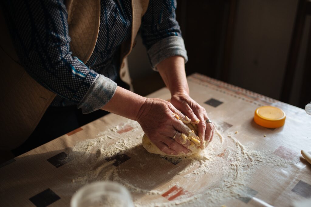 Manos de una panadera amasando pan. / A baker's hands kneading bread.