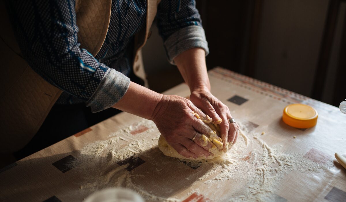 Manos de una panadera amasando pan. / A baker's hands kneading bread.