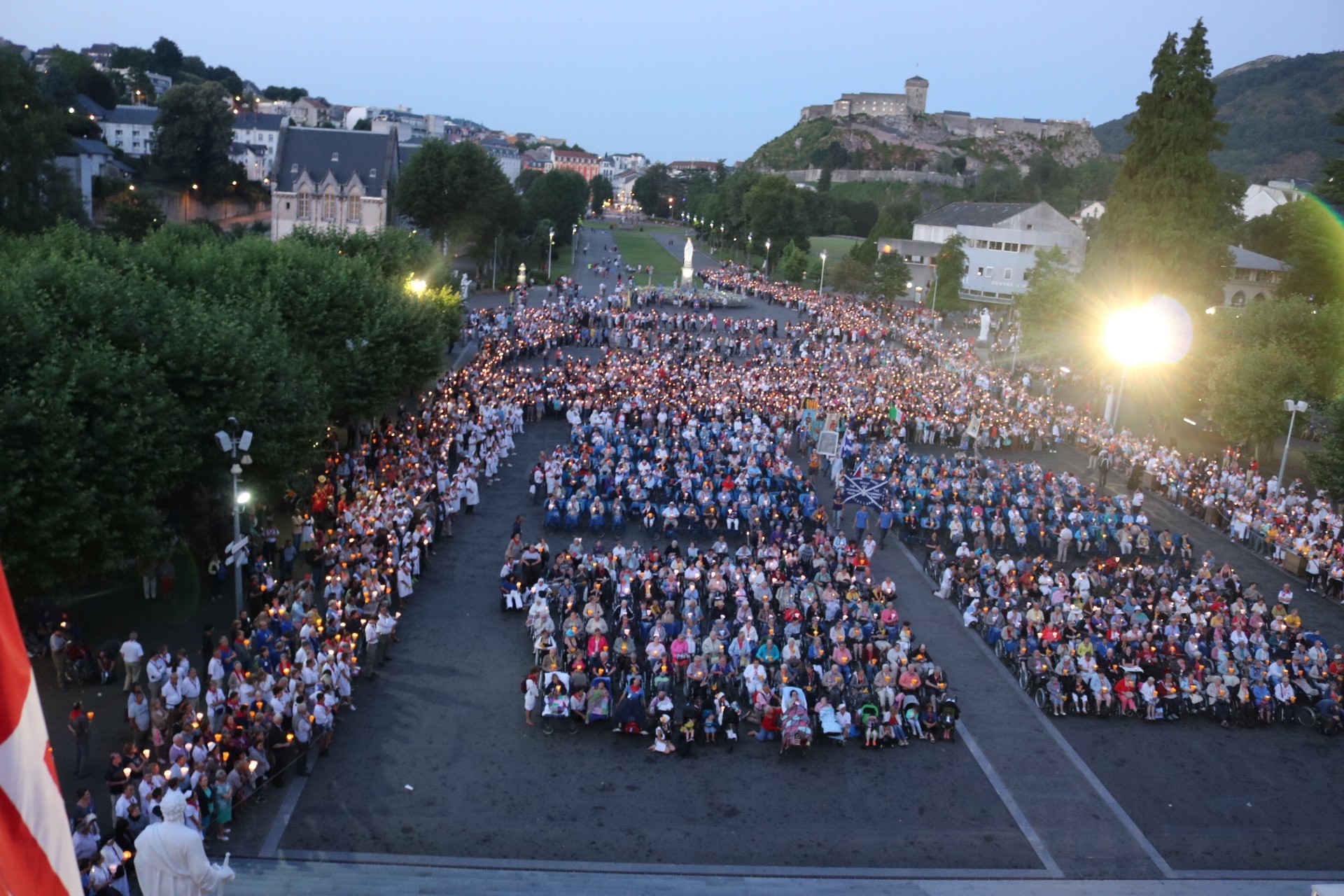 Peregrinos participan al anochecer en la procesión de las antorchas en la plaza del Rosario de Lourdes.