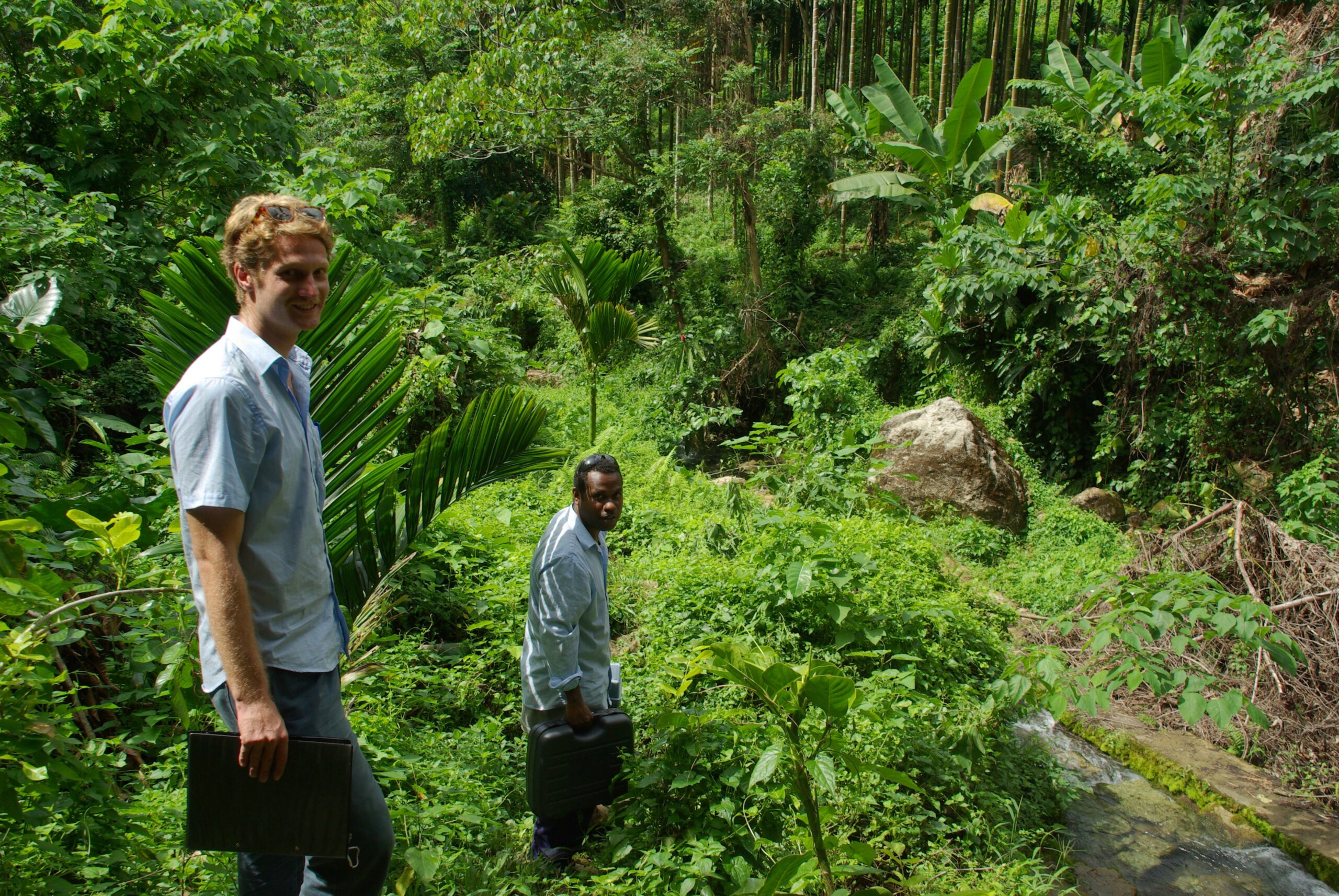 Dos voluntarios descienden desde un punto de abastecimiento de agua en Kongula.